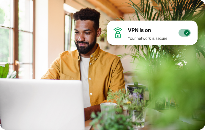 Man omgiven av växter som ler mot en laptop